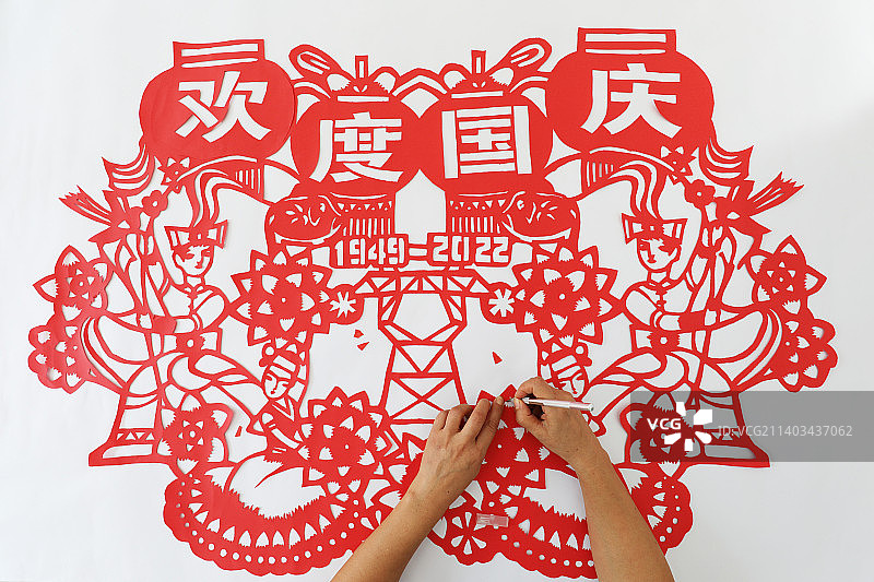 剪纸艺人在创作国庆主题剪纸图片素材