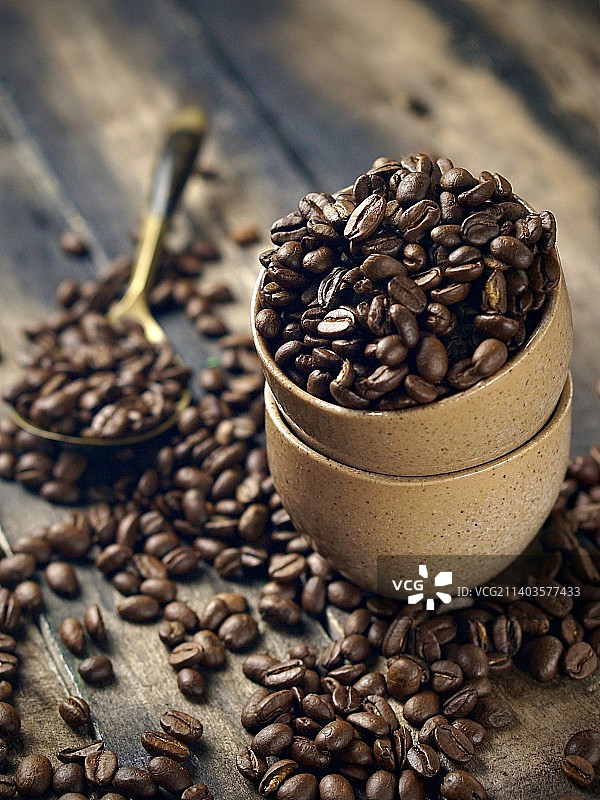 咖啡豆在杯中散落在木制底座下，八打灵再也，雪兰莪，马来西亚图片素材
