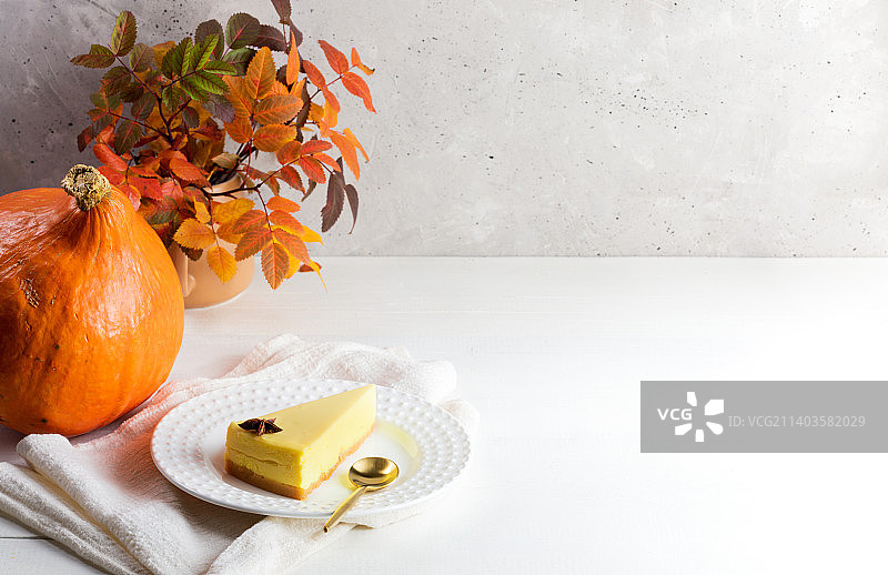 万圣节、感恩节概念：南瓜派、橙色南瓜、白色桌面上的秋叶图片素材