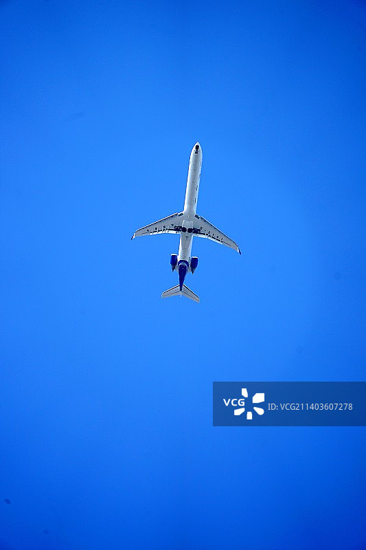 仰拍蓝天上飞得更高的大飞机图片素材