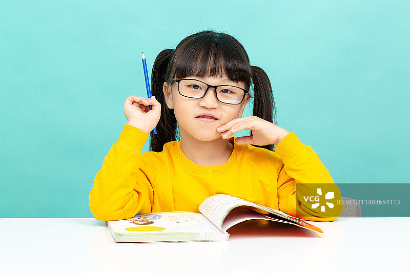 在学习桌前看书学习戴眼镜的中国小学生图片素材