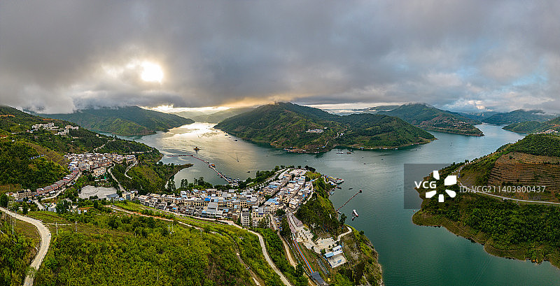 贵州黔西南望谟，清晨的日出云海印照红水河，天空和江水漫红，船只穿梭在江面。图片素材