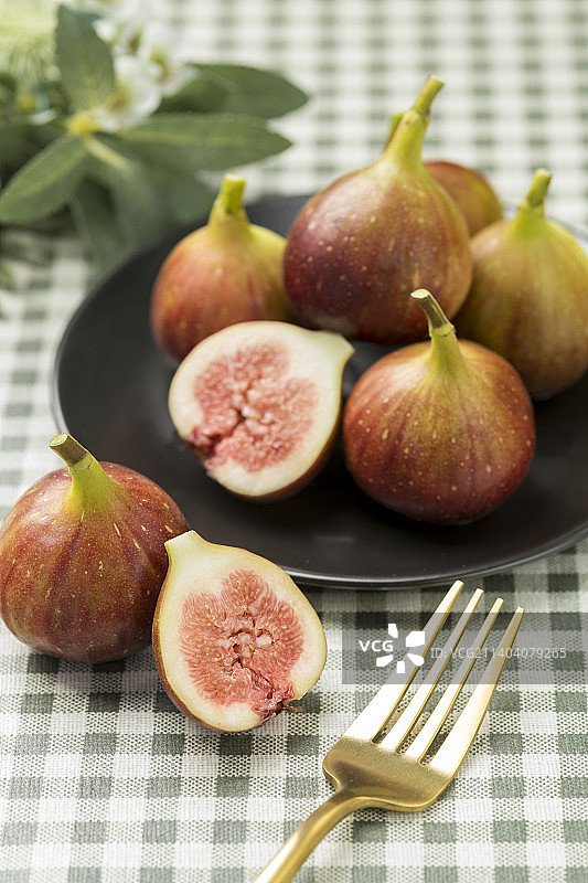 一盘新鲜的无花果摆放在桌面上特写图片素材