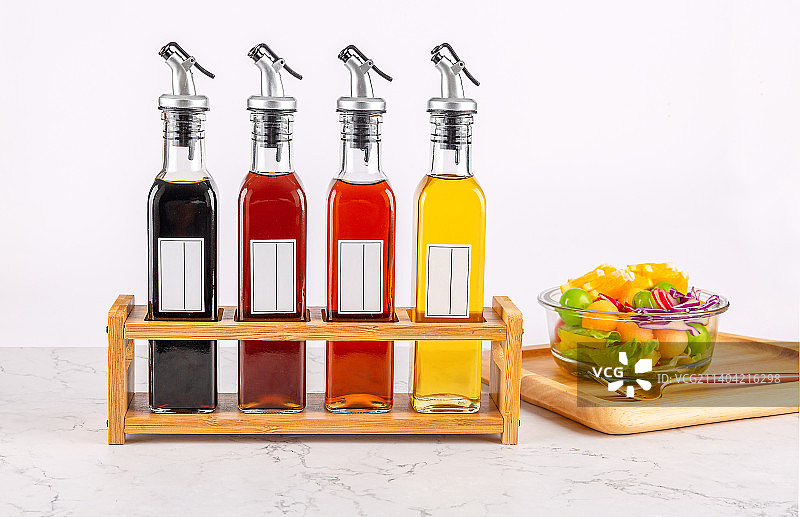 桌面上装满食用油和调味品的玻璃瓶图片素材