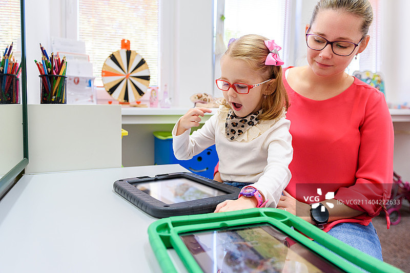 患有脑瘫的非语言女孩学习使用平板电脑进行交流，斯洛伐克图片素材