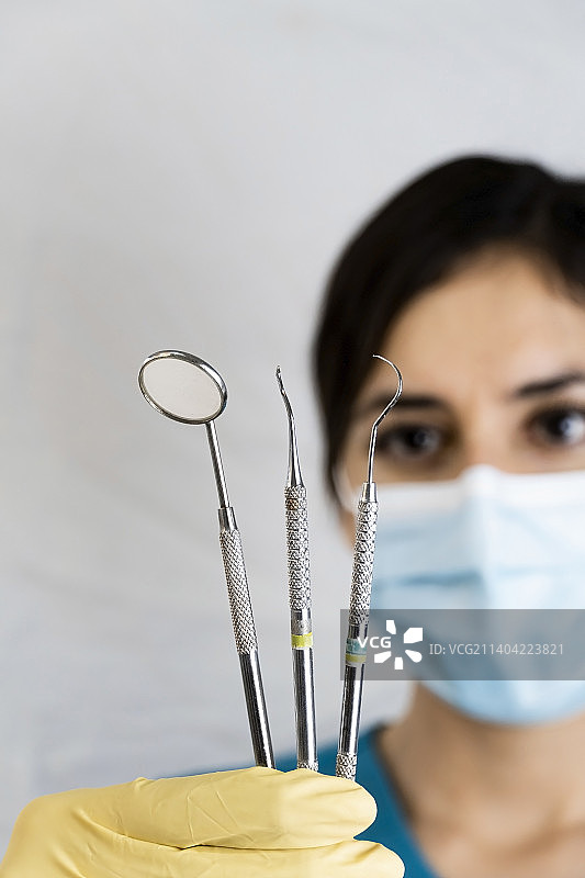 年轻的女牙医手中拿着牙科器械图片素材