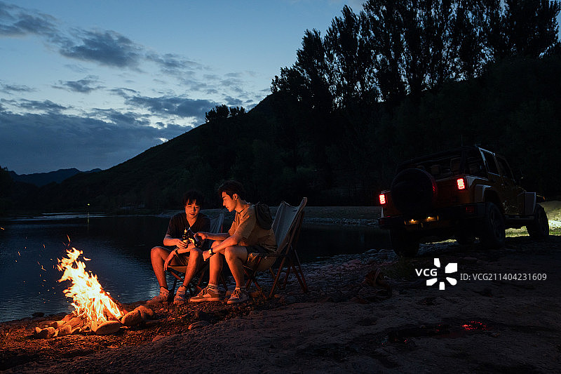 年轻人夜晚在野外篝火露营图片素材