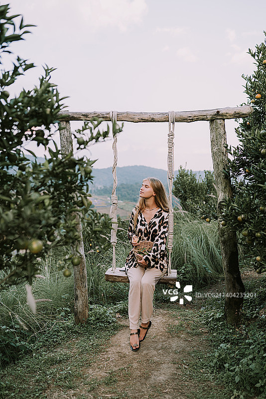 年轻金发女子在泰国夜丰颂府橙园中图片素材