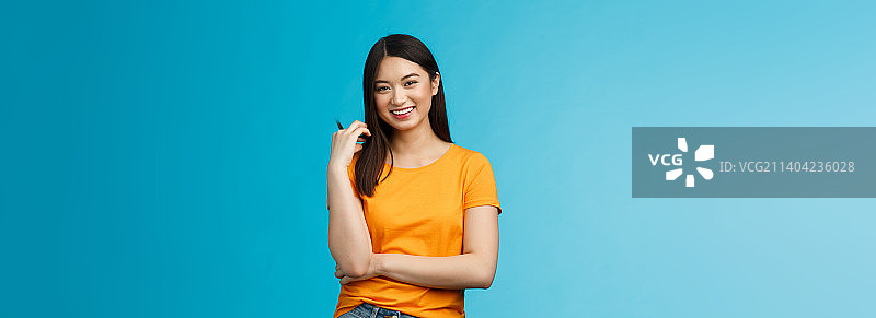 快乐的亚洲女孩，留着深色短发，抚摸着发丝图片素材