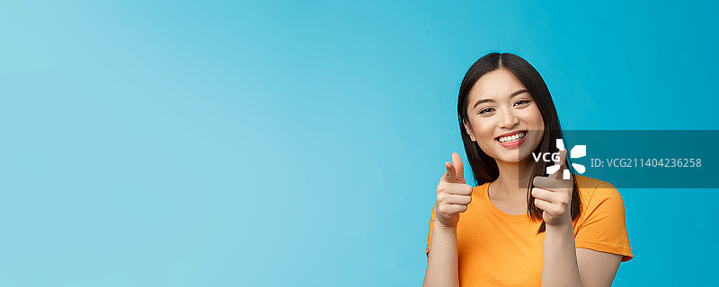 快乐友好的好看的现代亚洲女性展示手枪图片素材