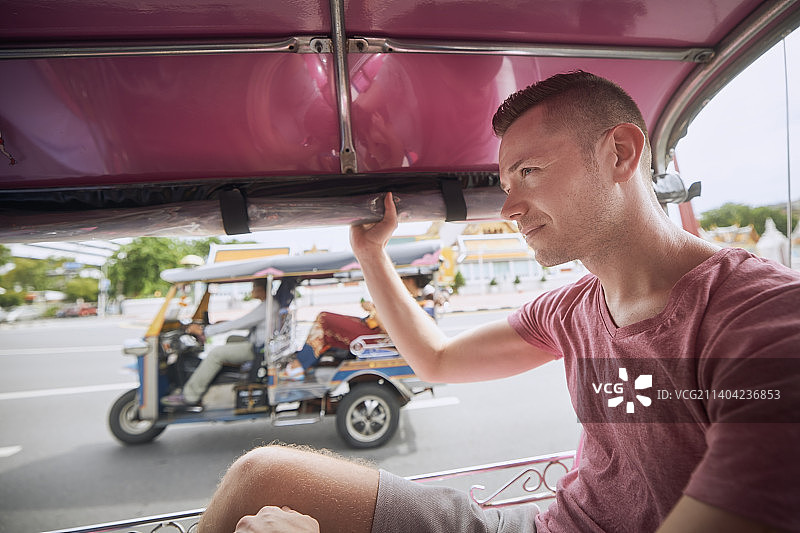 在曼谷乘坐嘟嘟车的男人图片素材