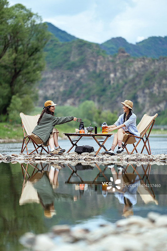 快乐的年轻女孩在河滩上露营图片素材