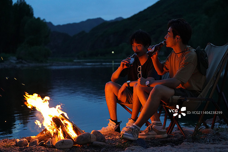 年轻人夜晚在野外篝火露营图片素材