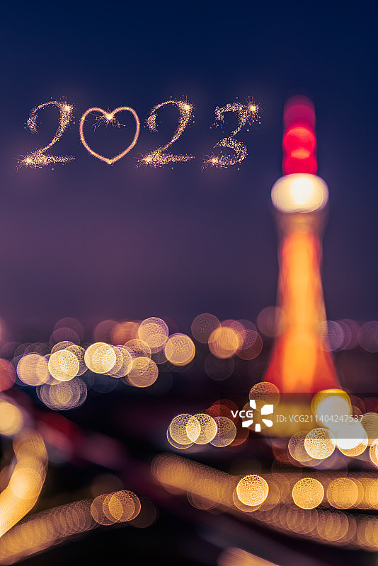2023新年火花字和朦胧的城市建筑夜景图片素材