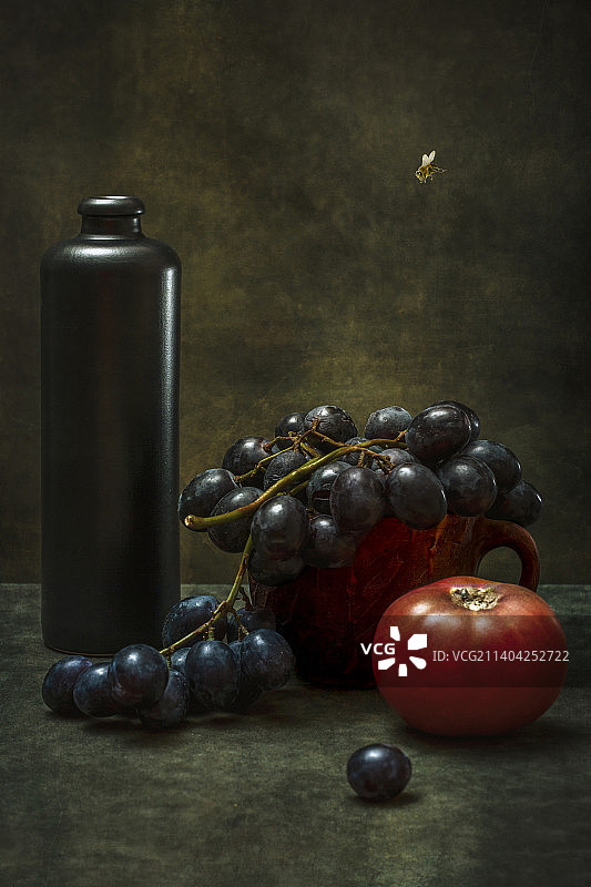 葡萄、番茄、深色瓶子和蜜蜂静物图片素材