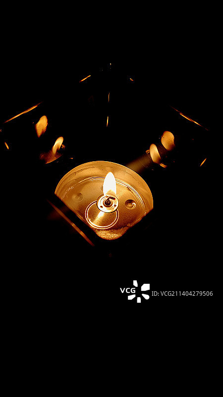 女性手持点亮的油灯，黑色背景图片素材