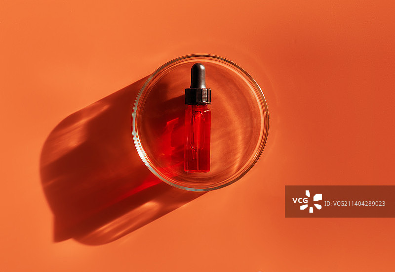 红色琥珀瓶、实验室玻璃培养皿和水滴移液器图片素材