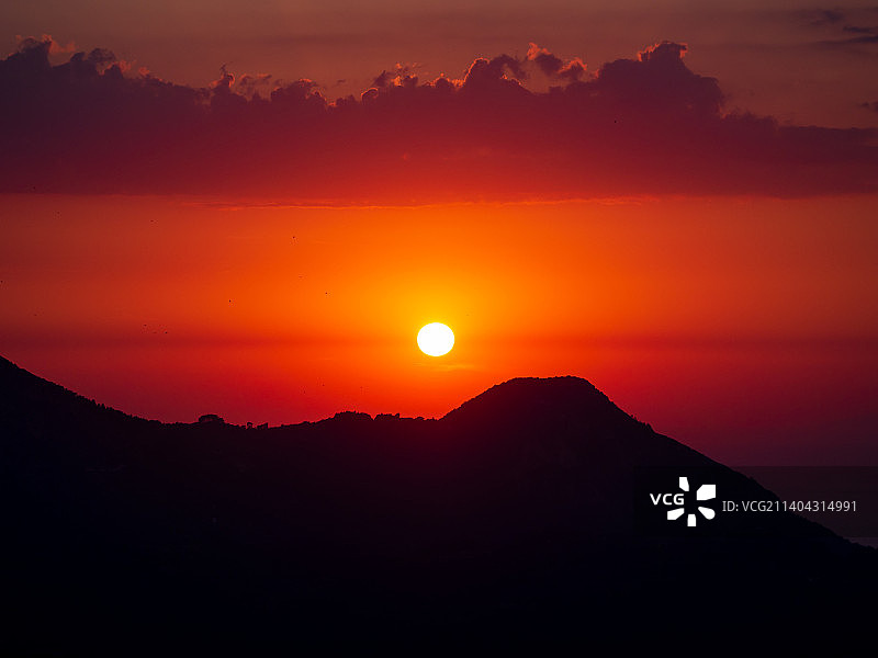 橙色天空映衬下的山的剪影图片素材