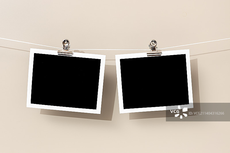 两个悬挂在绳子上的空白复古即时照片相框图片素材