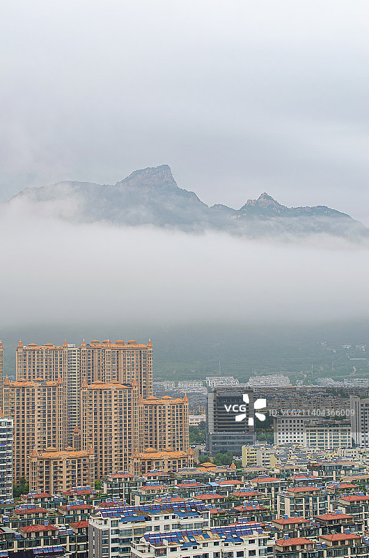 中国城市市风光拍摄主题，山东省泰安市泰山区，傲崃峰山脉和天空的乌云和城市居住区，户外白昼无人图像摄影图片素材