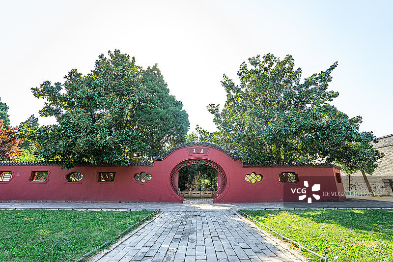 中国山东泰安著名景点泰山旅行旅游目的地，泰山第一行宫岱庙，素景中式庭院里的月亮门和花坛，户外白昼无人图片素材