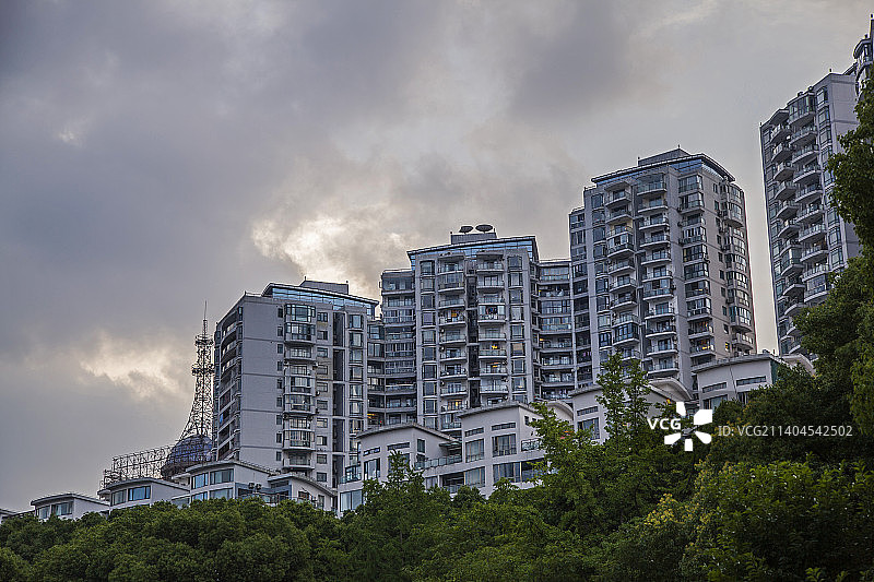 乌云下亮着灯光的住宅楼群图片素材