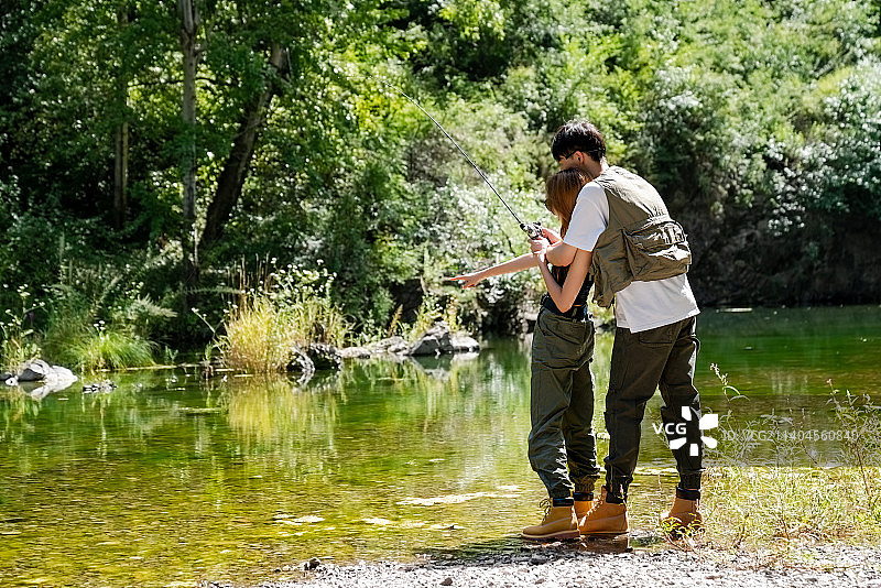 小溪边垂钓的青年情侣图片素材