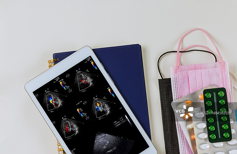 使用数码平板电脑，医生检查超声心动图结果图片素材