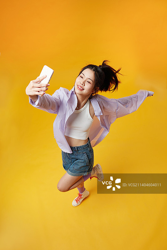 高角度下使用手机的年轻女孩图片素材