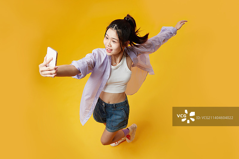 高角度下使用手机的年轻女孩图片素材