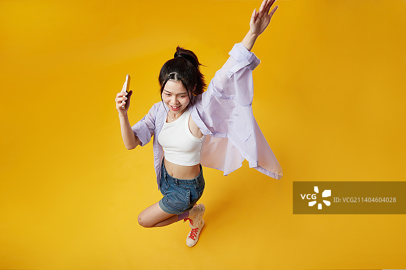 高角度下使用手机的年轻女孩图片素材