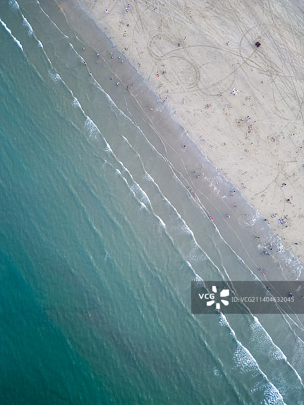 下午日光下航拍视角的蓝色海水和白色沙滩图片素材