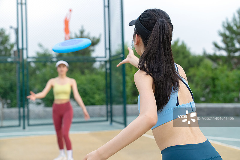 操场上玩飞盘的女大学生图片素材