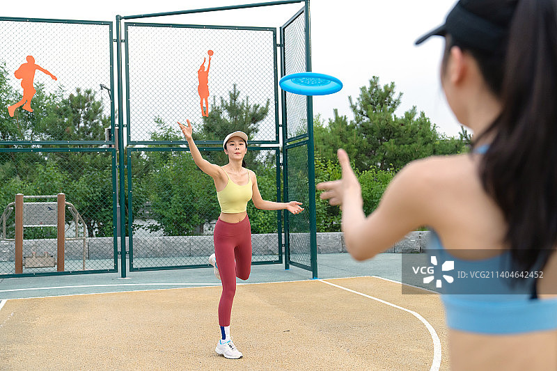 操场上玩飞盘的女大学生图片素材