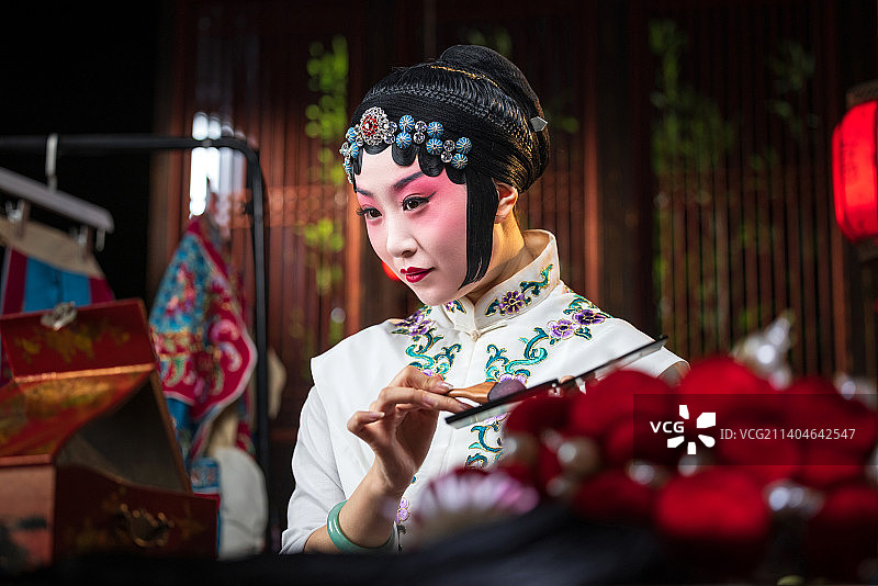 京剧女演员对着镜子佩戴首饰图片素材