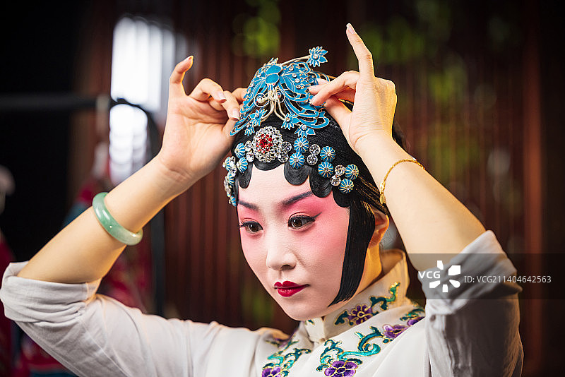 京剧女演员对着镜子佩戴首饰图片素材