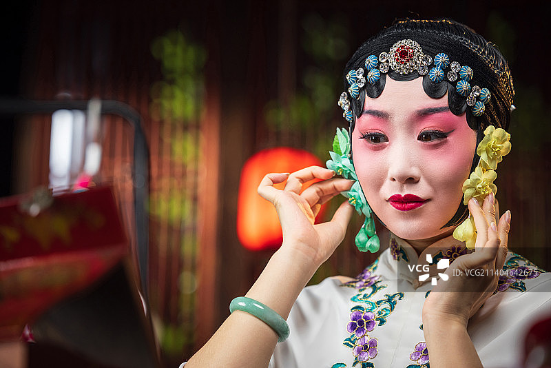 京剧女演员对着镜子佩戴首饰图片素材