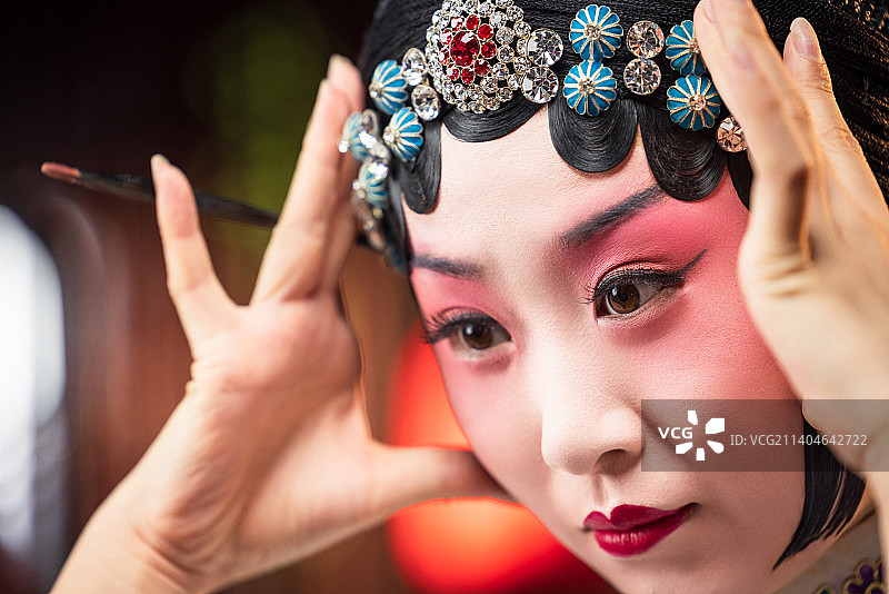 京剧女演员对着镜子佩戴首饰图片素材