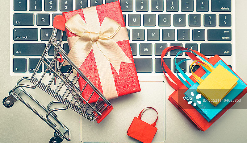 双十一购物节，笔记本电脑上的购物袋和购物车图片素材