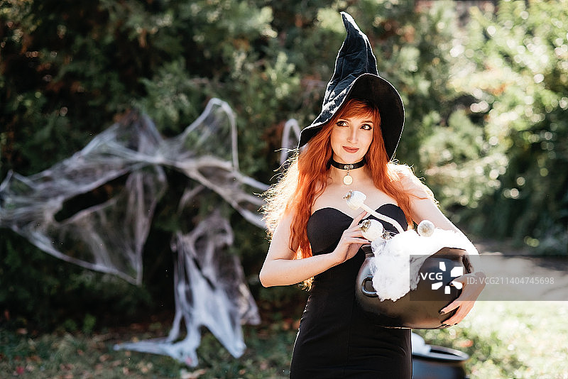 万圣节：戴女巫帽的漂亮年轻女巫图片素材