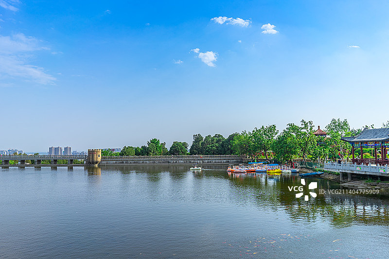 中国山东省泰安市泰山区虎山公园，傍晚的湖泊拍摄主题，前景的树枝和远处的山峰，户外无人图像摄影图片素材