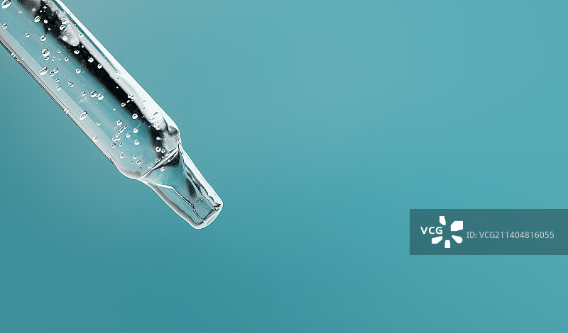 蓝色背景上透明质酸滴管化妆品特写图片素材