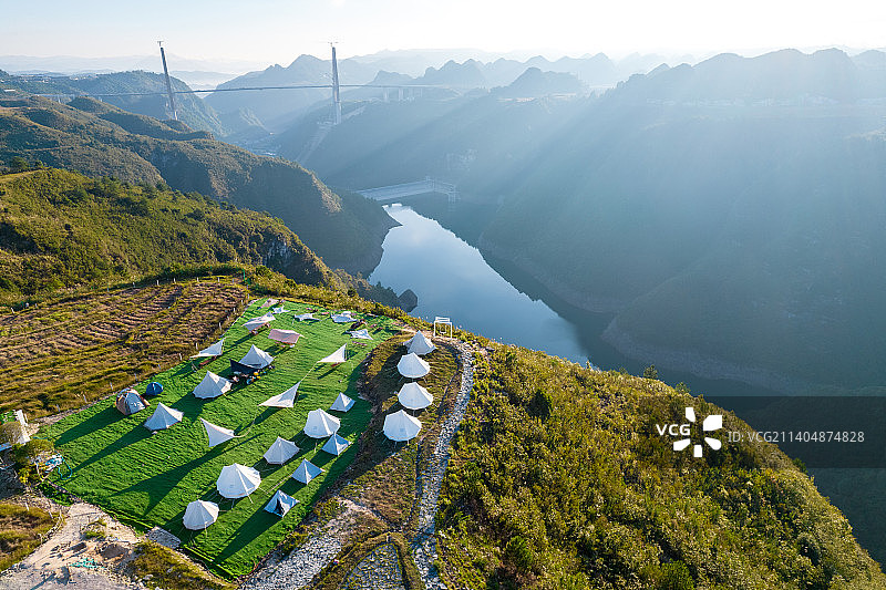 清晨峡谷湖边的梯田上的露营地图片素材