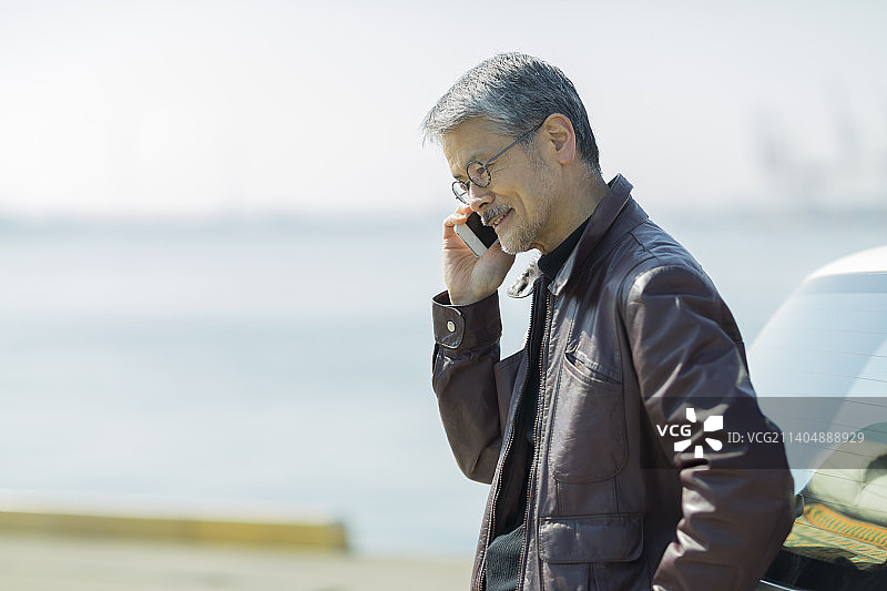 年长的男人用智能手机通话图片素材