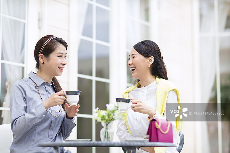 两位女士手持咖啡杯欢笑图片素材