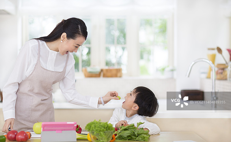 妻子在厨房给孩子喂水果图片素材