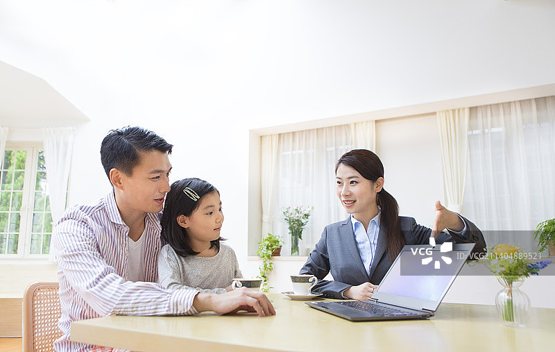 父女听上门推销员讲解图片素材