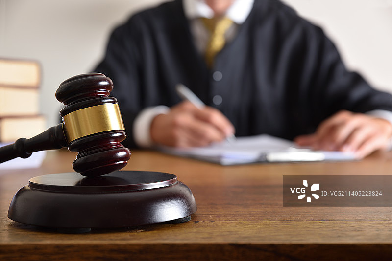法槌和法官在办公桌前签字的细节图片素材