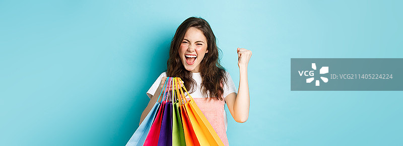 兴奋的年轻女子喜悦尖叫，握拳庆祝图片素材