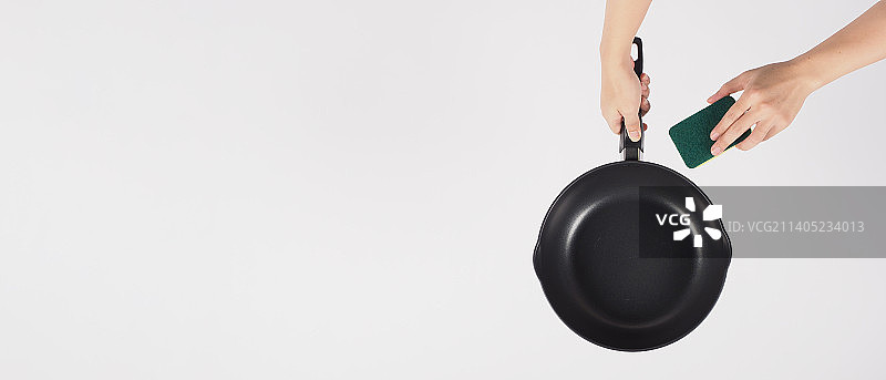 用抹布清洁不粘锅图片素材